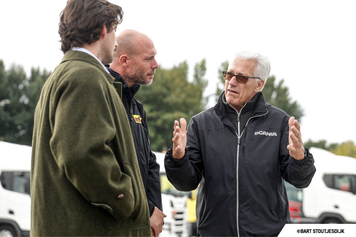 Drie mannen praten buiten op het terrein van de Scania Drivedays