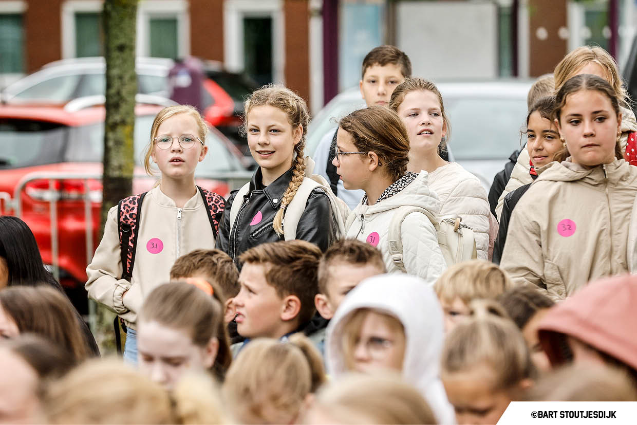 Groep basisschoolleerlingen wacht samen op de Onderwijsdag van de bouw
