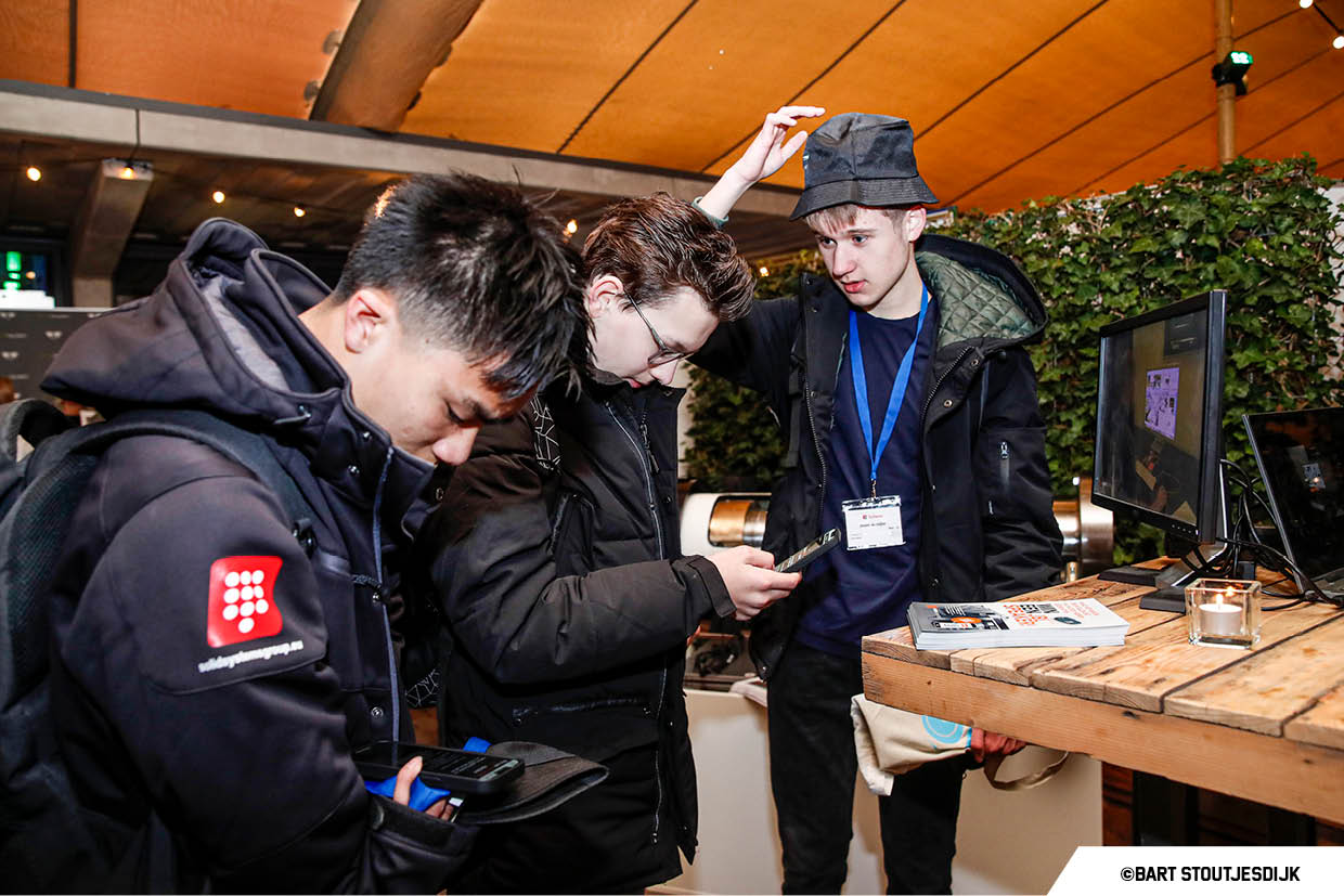 Drie jongeren kijken naar informatie bij een stand op Werkend Altena