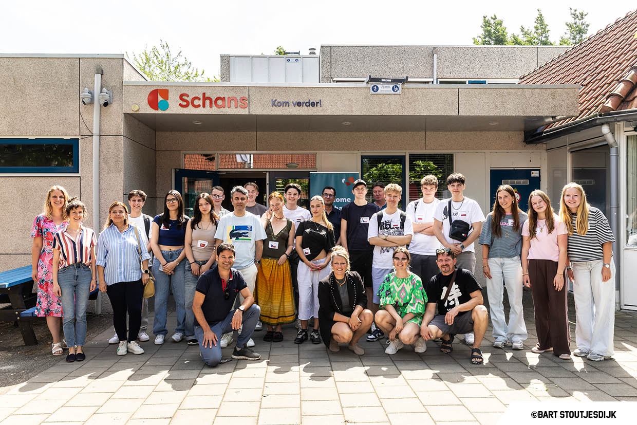 Groep leerlingen en begeleiders poseert voor de ingang van Schans tijdens een internationaal project