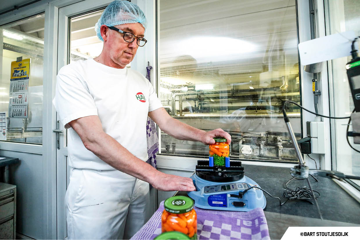 Medewerker test de sluiting van een pot groenten in het laboratorium van HAK