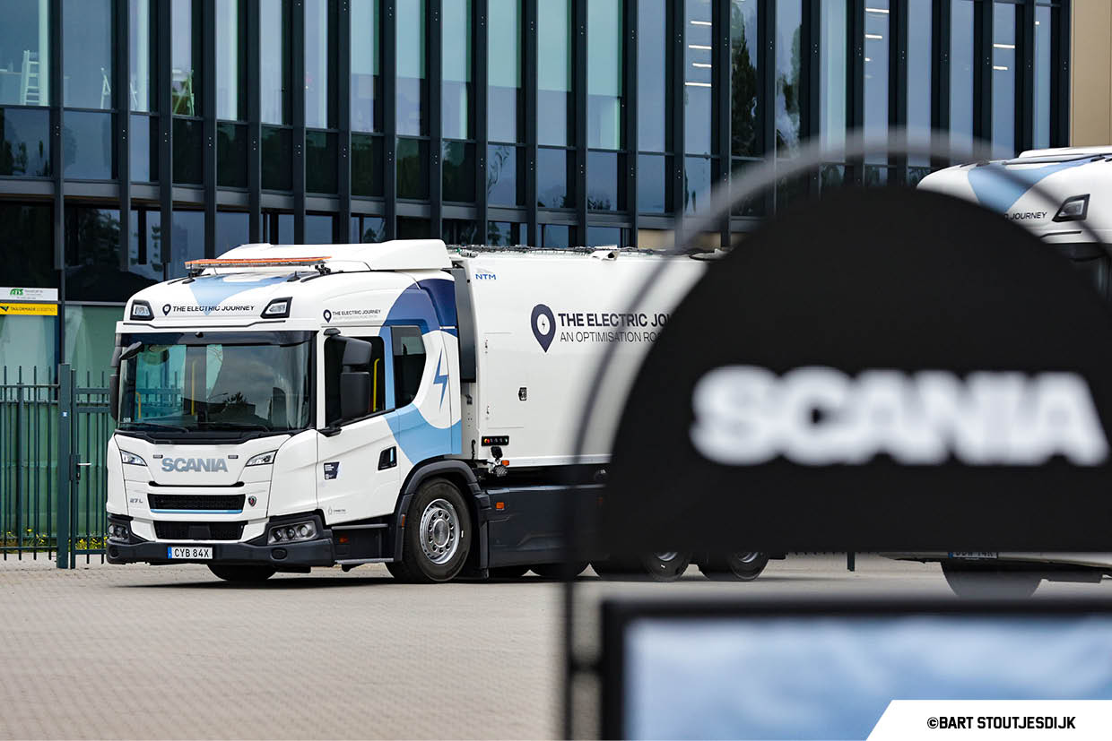 Witte Scania-bakwagen met The Electric Journey voor een kantoorpand
