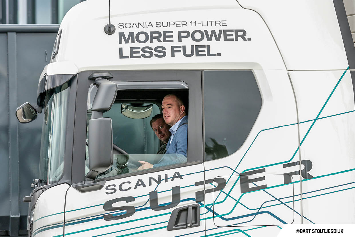 Twee mannen maken een proefrit in de cabine van een Scania